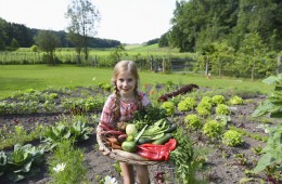 Mädchen im Garten hält Gemüse